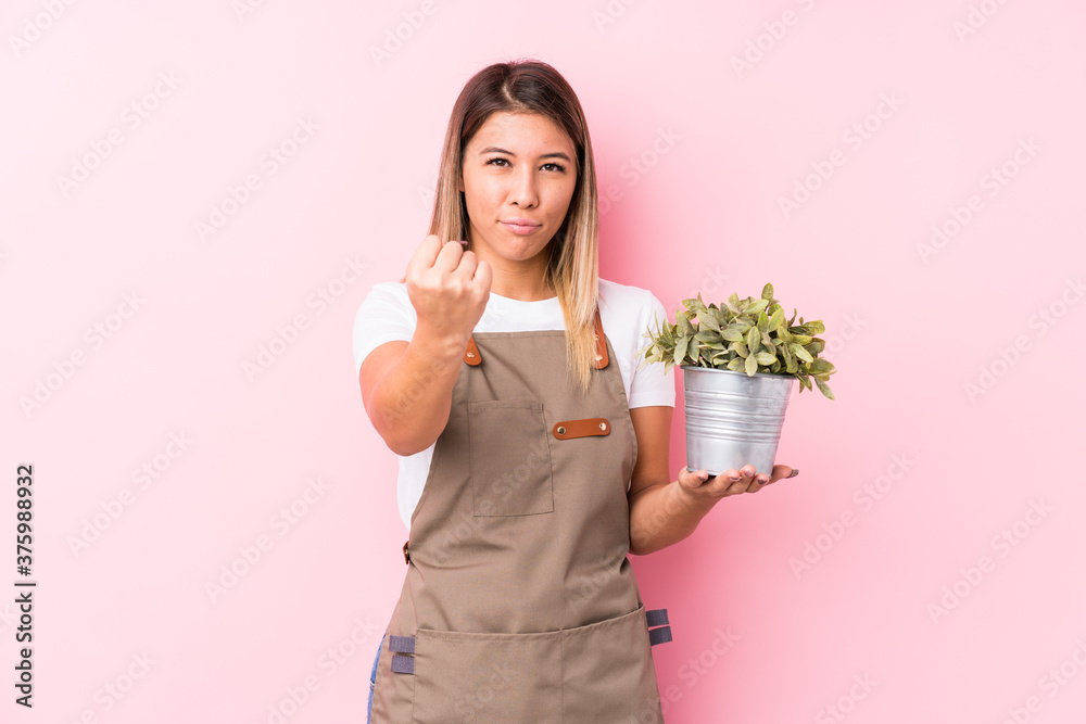 Young gardener caucasian woman isolated showing fist to camera, aggressive facial expression. Young gardener caucasian woman isolated showing fist to camera, aggressive facial expression.