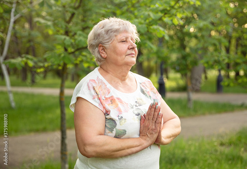 Mature lady relaxing in nature. Woman meditating. Healthy lifestyle