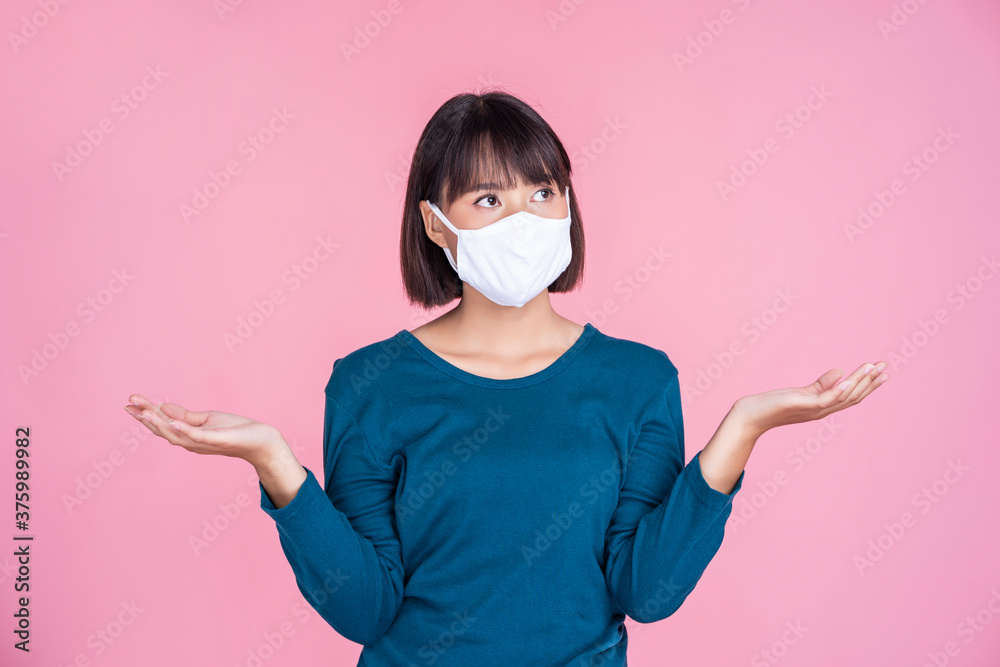 Asian businesswoman work from home wearing pm2.5 panic white face mask confused upset anger safety protection coronavirus covid-19 illness, portrait female looking camera pink isolated background Asian businesswoman work from home wearing pm2.5 panic white face mask confused upset anger safety protection coronavirus covid-19 illness, portrait female looking camera pink isolated background