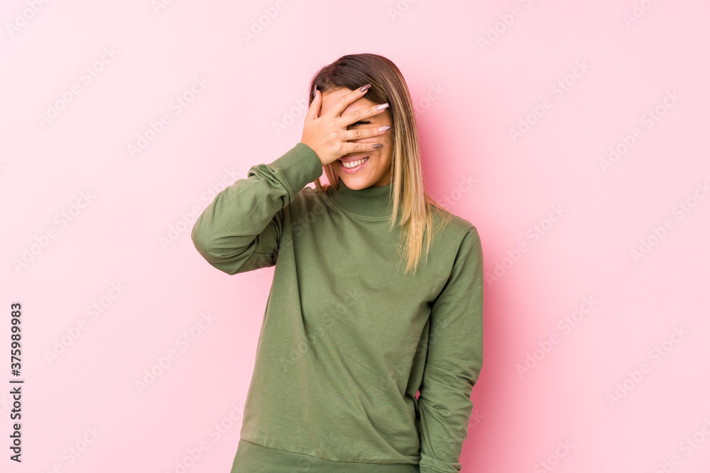 Young caucasian woman posing isolated blink at the camera through fingers, embarrassed covering face. Young caucasian woman posing isolated blink at the camera through fingers, embarrassed covering face.