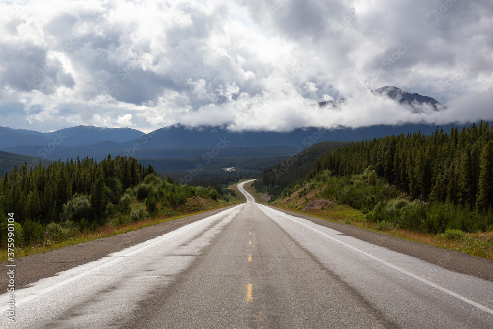 Beautiful View of a scenic road in the Northern Rockies during a sunny and cloudy morning. Taken in British Columbia, Canada. Nature Background