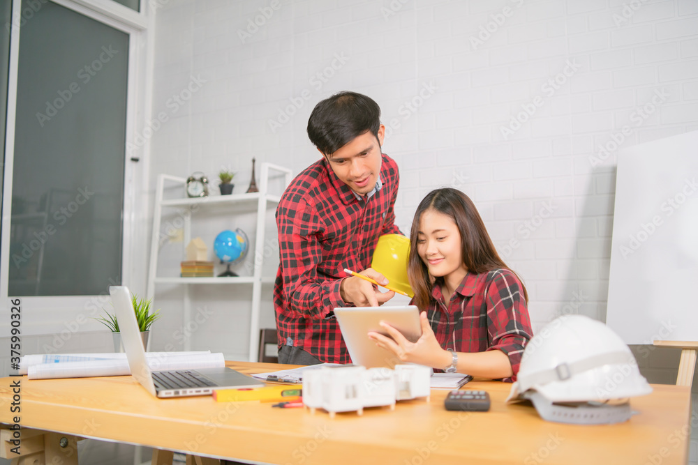 Obraz premium Asian architect man and woman working with laptop and blueprints,engineer inspection in workplace for architectural plan,sketching a construction project ,selective focus,Business concept