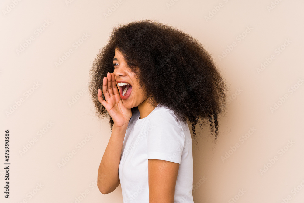 Young african american woman shouting and holding palm near opened mouth.