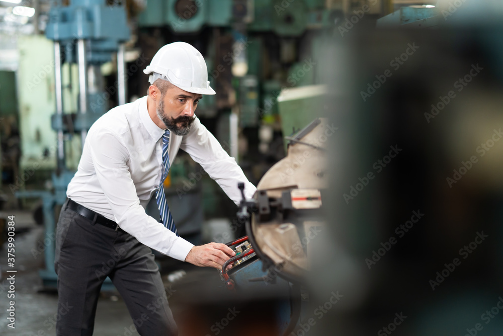 Man at work. Mechanical Engineer Bearded man in Hard Hat in Heavy Industry Manufacturing Facility. Professional Engineer Operating lathe Machinery Man at work. Mechanical Engineer Bearded man in Hard Hat in Heavy Industry Manufacturing Facility. Professional Engineer Operating lathe Machinery