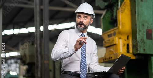 Man at work. Mechanical Engineer Bearded man in Hard Hat in Heavy Industry Manufacturing Facility. Professional Engineer Operating lathe Machinery