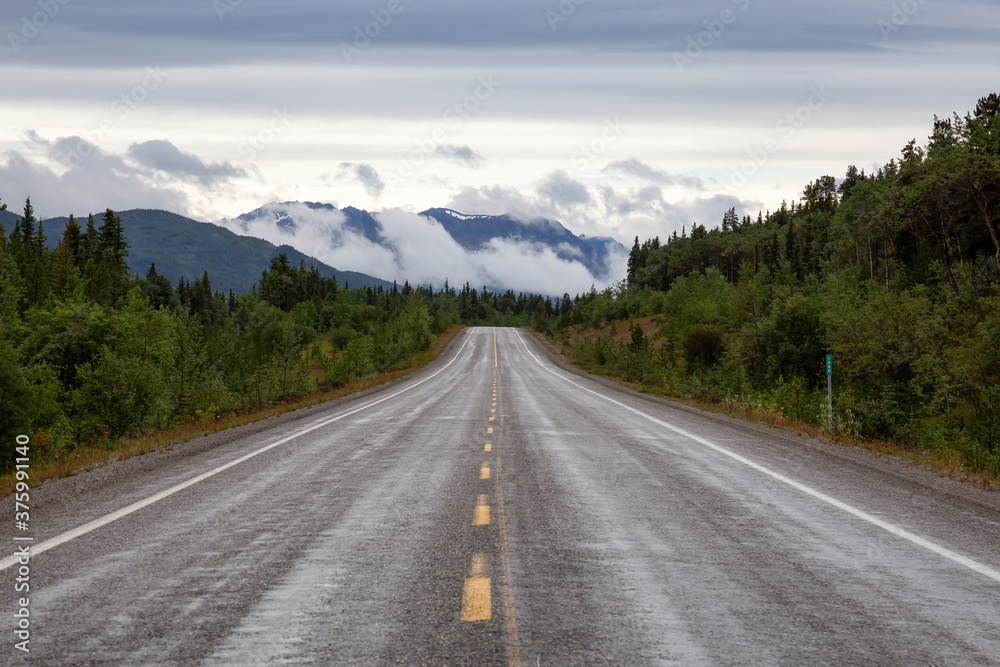 Beautiful View of a scenic road in the Northern Rockies during a sunny and cloudy morning. Taken in British Columbia, Canada. Nature Background