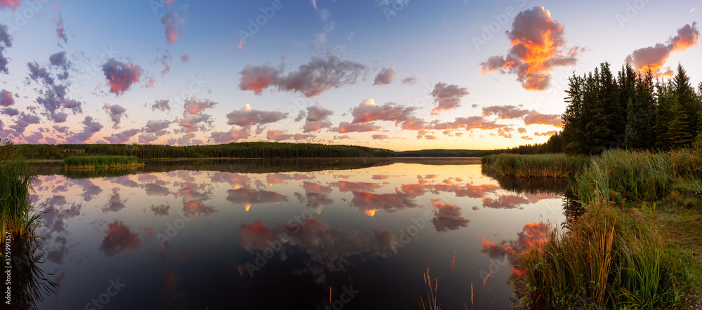 Beautiful Panoramic View of a Colorful Sunrise with Water Reflection at the Lake. Taken in Northern British Columbia, Canada. Nature Panorama Background