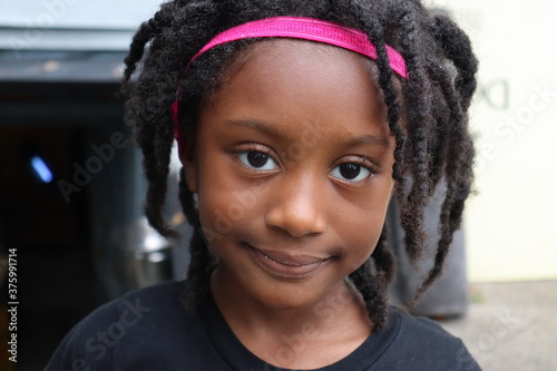 Cute young black girl wearing pink headband close up head shot photo