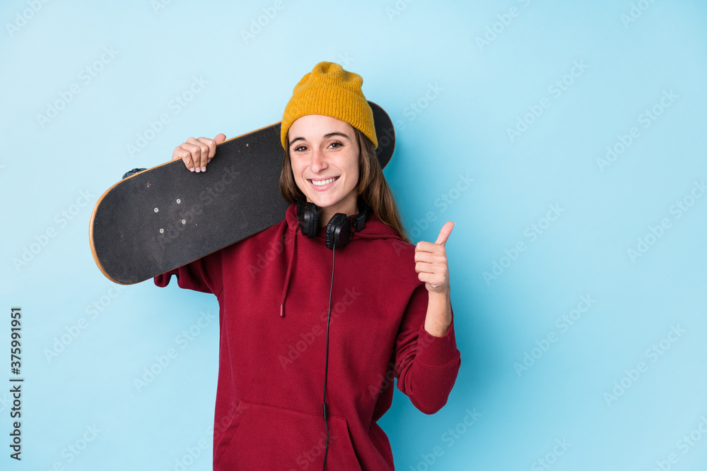 young skater caucasian woman isolated smiling and raising thumb up