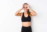Young caucasian fitness woman posing in a white background showing okay sign over eyes