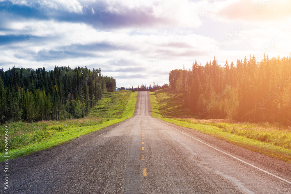 Fototapeta premium Beautiful View of a scenic road in the Northern Rockies during a sunny and cloudy day. Taken in British Columbia, Canada. Nature Background Panorama
