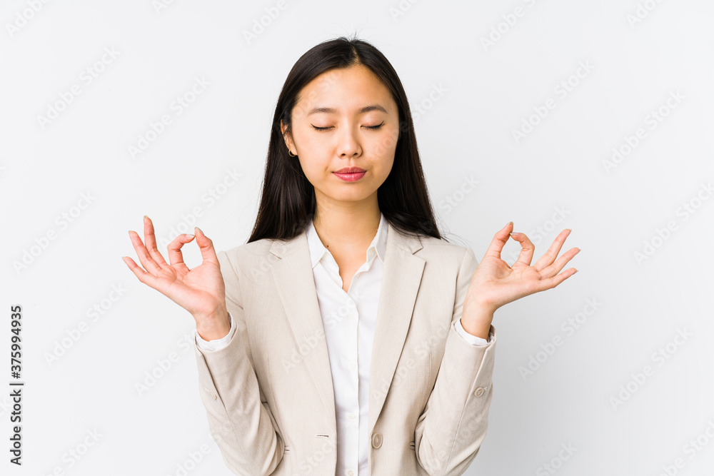 Young chinese business woman isolated relaxes after hard working day, she is performing yoga. Young chinese business woman isolated relaxes after hard working day, she is performing yoga.