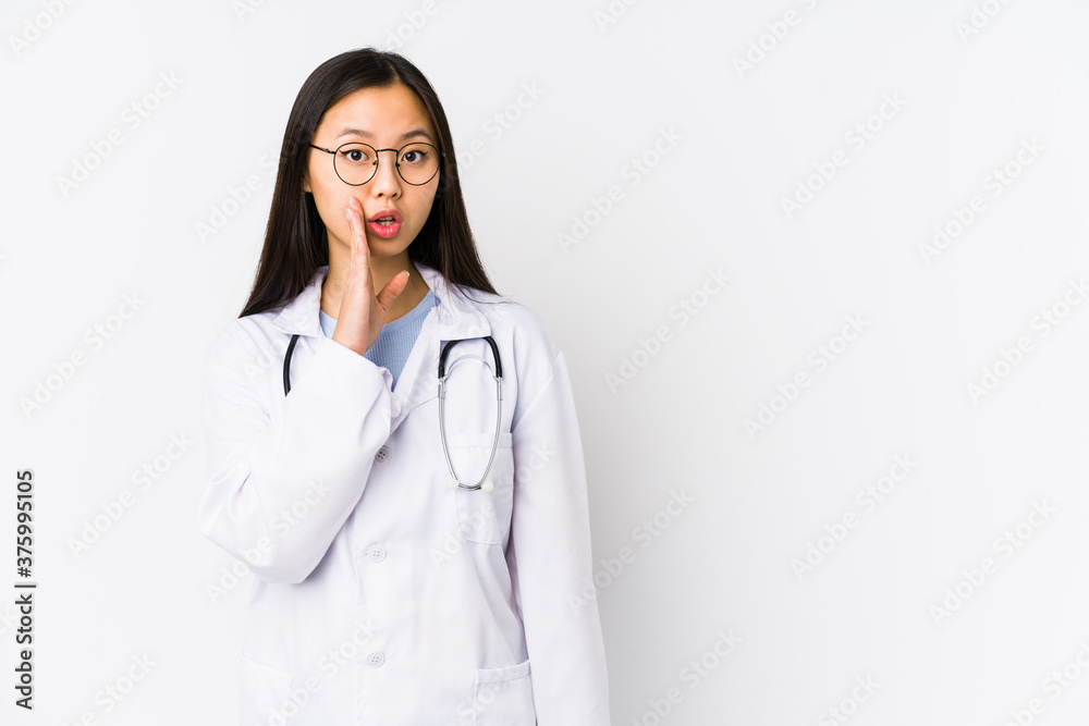 Young doctor chinese woman isolated is saying a secret hot braking news and looking aside Young doctor chinese woman isolated is saying a secret hot braking news and looking aside