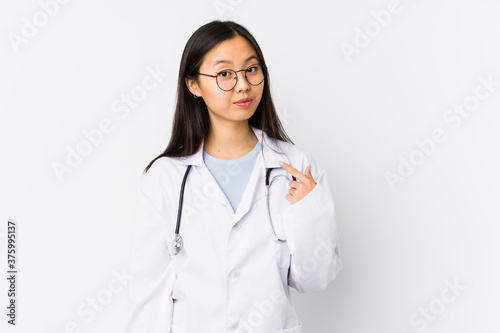 Young doctor chinese woman isolated pointing with finger at you as if inviting come closer.
