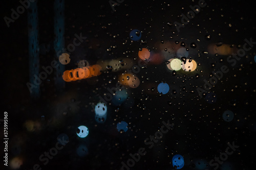 Droplets with city blurring lights abstract circular bokeh in the background
