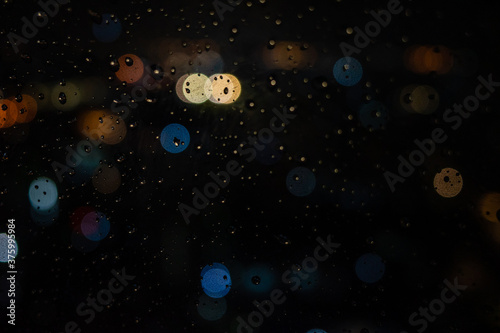 Droplets with city blurring lights abstract circular bokeh in the background