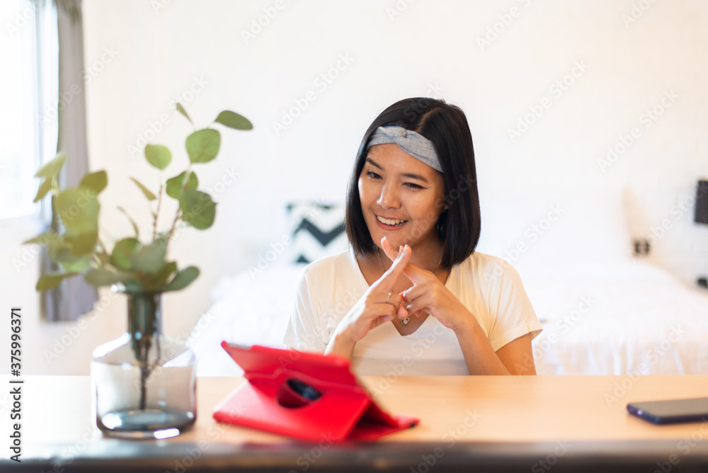Happy asian woman communicating via sign hands language on video call to a deaf person Happy asian woman communicating via sign hands language on video call to a deaf person