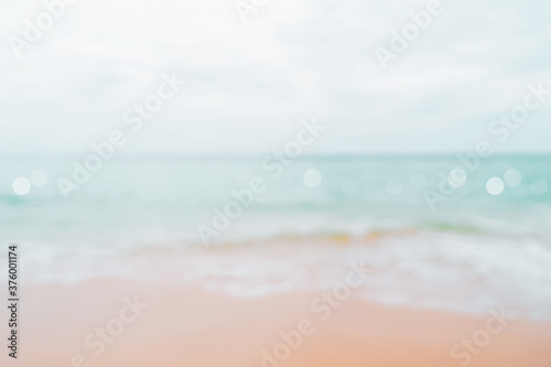 Blur tropical nature clean beach and white sand in summer with sun light blue sky and bokeh