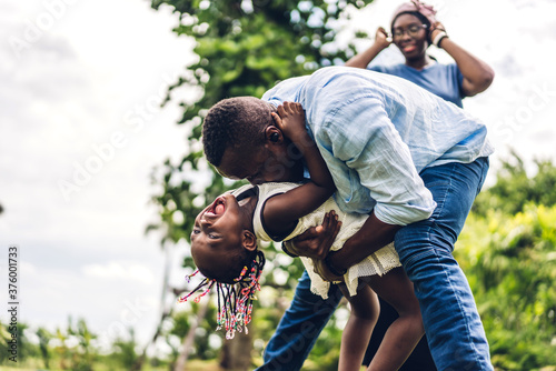 Portrait of enjoy happy love black family african american father and mother with little african girl child smiling and having fun moments good time in summer park at home