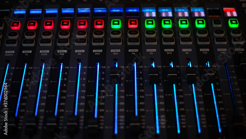 Digital Music mixer with buttons and sliders control panel in a recording Studio