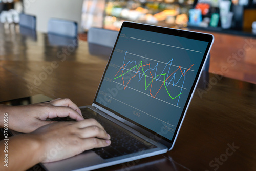 Businessman using a laptop with data analytics and statistics information business technology on table top. mockup with clipping path.