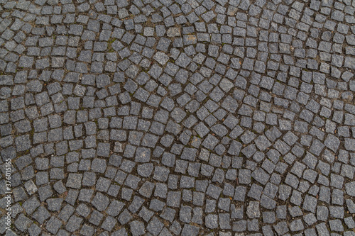 Fotografia old granite cobblestones close up lined with an arc