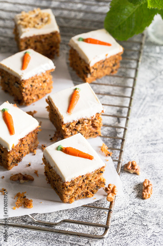 pieces of carrot cake with walnuts with icing cream on a light background. tinting. selective focus