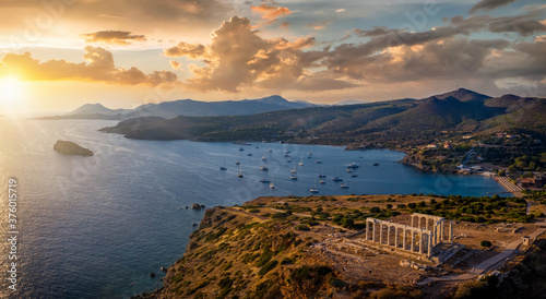 Panorama des Kap Sounion bei Athen zum Sonnenuntergang mit Tempel des Poseidon und zahlreichen Segelbooten vor Anker in der Bucht, Attika, Griechenland photo