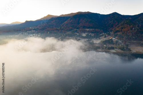 Lovely autumnal landscape with fog over the lake. © erika8213