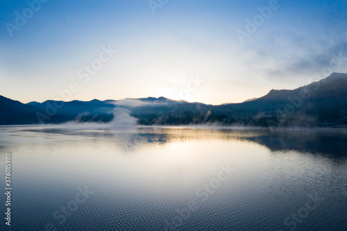 Lovely autumnal landscape with fog over the lake. © erika8213