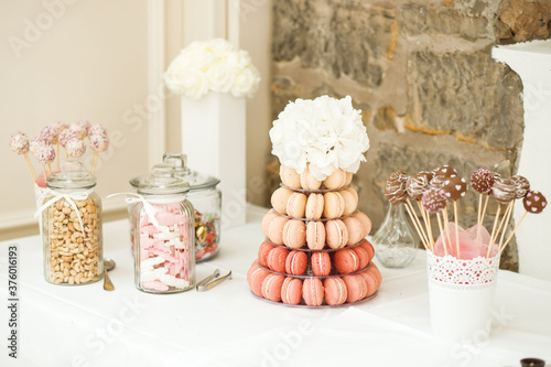 Close up of festive wedding tables with sweets, candies, dessert and fresh flowers photo