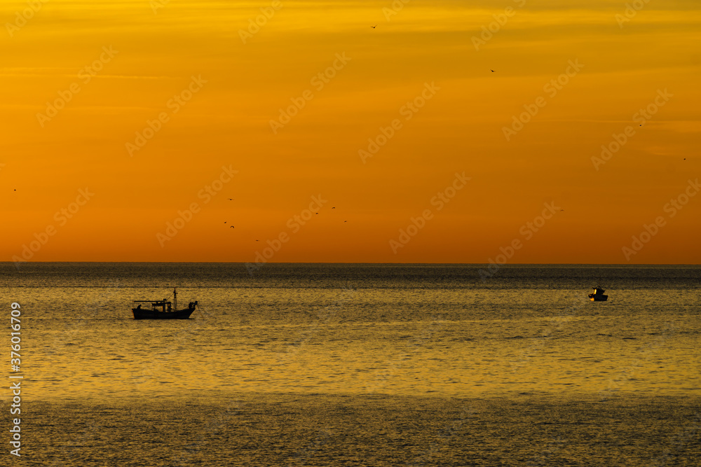 Fishing boat on sea at sunrise