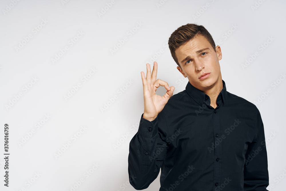 Man in black shirt lifestyle emotions modern style cropped view light background Man in black shirt lifestyle emotions modern style cropped view light background