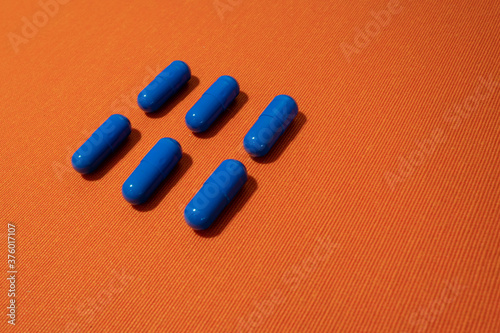 Blue pills on the orange background