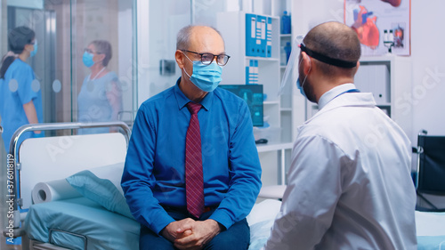 Doctor explaining to the patient the steps to be followed during COVID-19. Modern private hospital or clinic. Healthcare medical physician consultation during COVID-19 pandemic