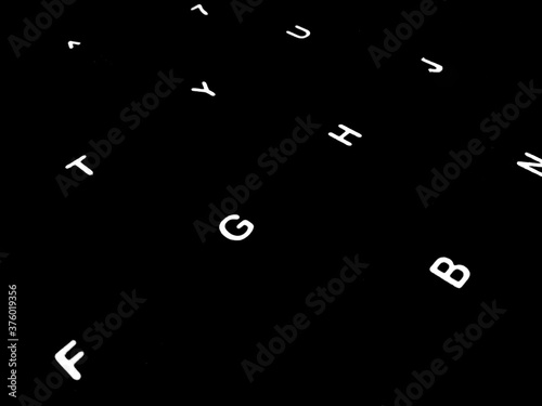 Creative Fine Art Image Illustration of White Glowing English Alphabet Letters On Dark Black Background Copy Space For Text. Modern abstract front style in computer keyboard typewriter sequence order.