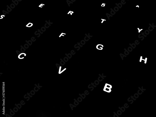 Creative Fine Art Image Illustration of White Glowing English Alphabet Letters On Dark Black Background Copy Space For Text. Modern abstract front style in computer keyboard typewriter sequence order.