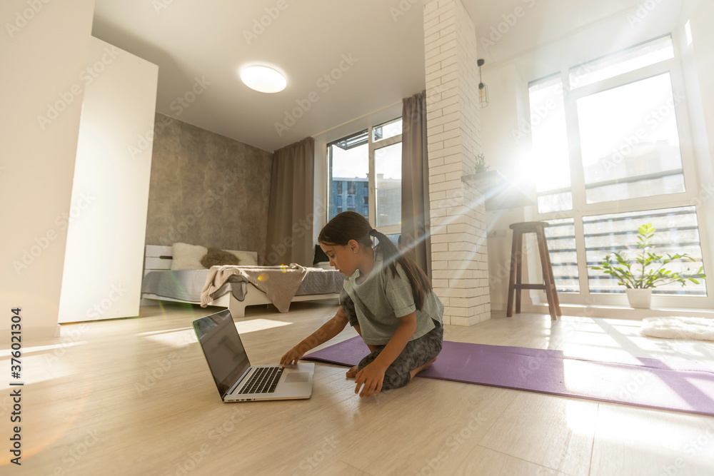 Little girl doing her homework at home and using a laptop Little girl doing her homework at home and using a laptop