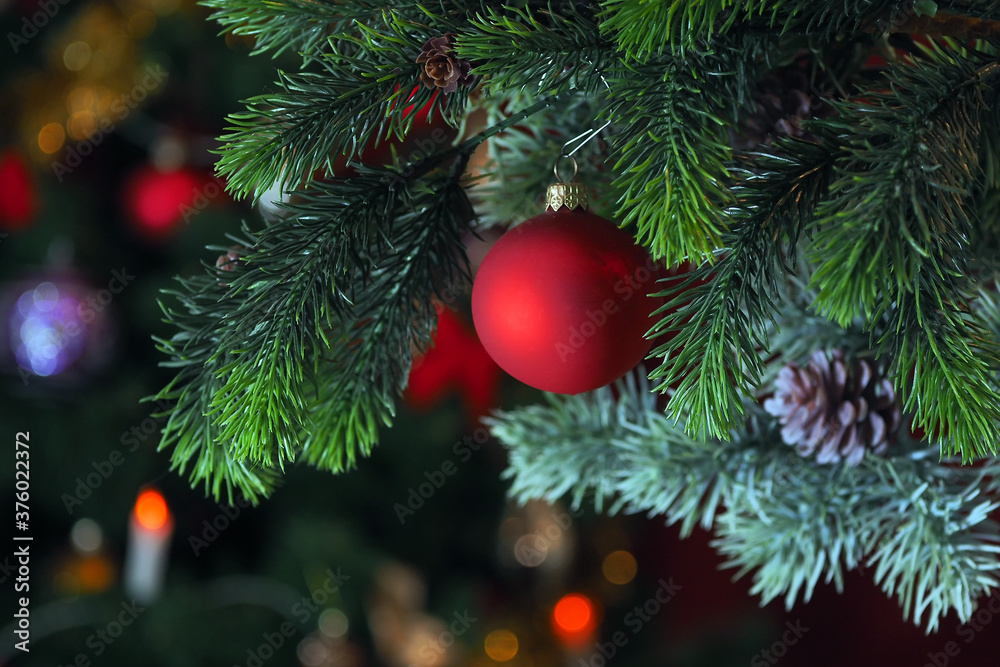 Christmas decoration on a Christmas tree branch with cones. Red Christmas ball on a Christmas tree. Christmas background