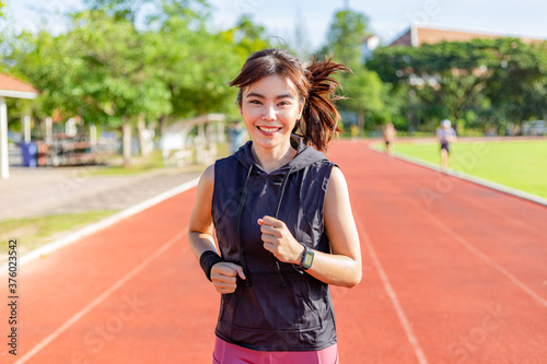 Beautiful young Asian woman exercising in the morning at a running track