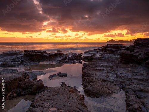 Golden Seaside Sunrise with Rockpool Reflections and Crashing Waves © Kevin