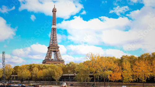 Eiffel Tower with autumn leaves  and cloudy sky in Paris, France © SASITHORN