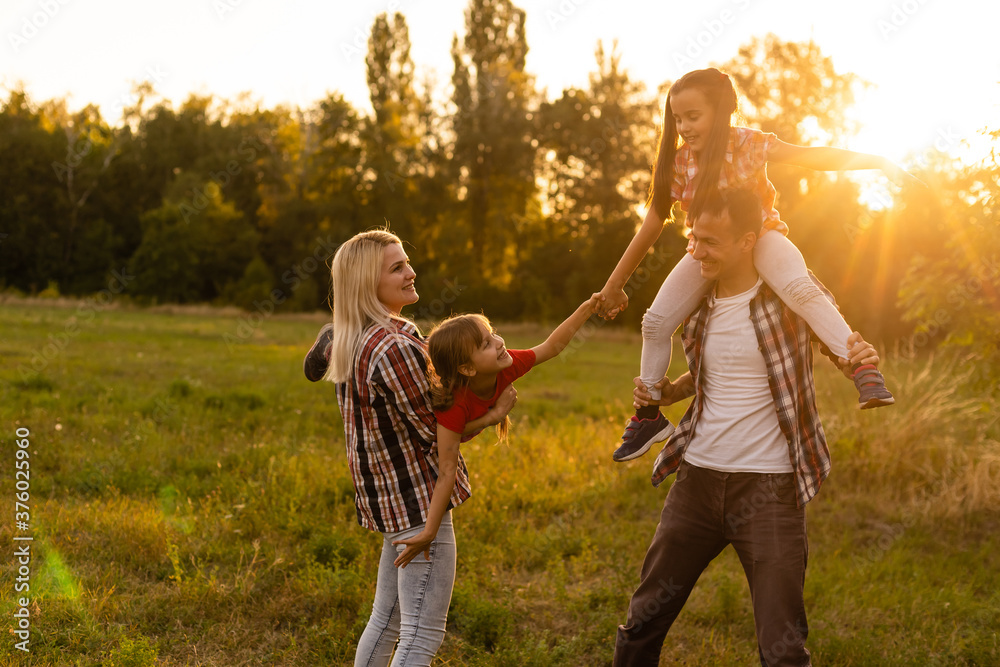 Fototapeta premium Happy family: mother father and child daughter on nature on sunset