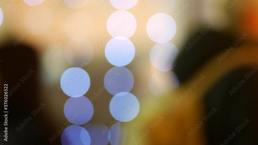 Silhouettes of unrecognizable people on abstract Christmas background in bokeh. Light of blinking garland blur. Bulbs of Christmas decorations tree. Festive mood. Animated background. New Year holiday Silhouettes of unrecognizable people on abstract Christmas background in bokeh. Light of blinking garland blur. Bulbs of Christmas decorations tree. Festive mood. Animated background. New Year holiday