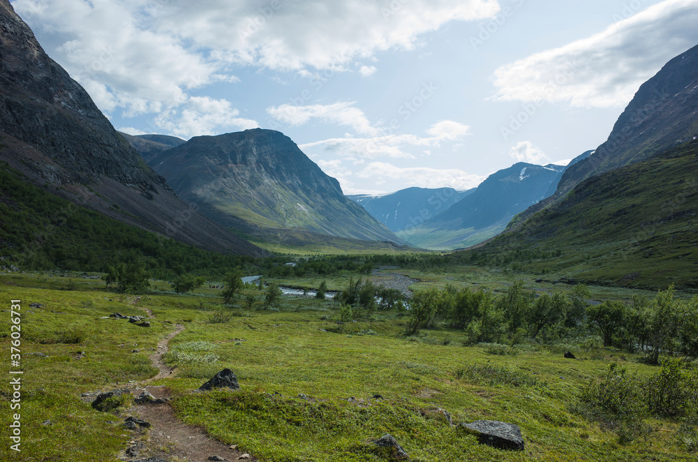 Hiking trail in Vistasvagge valley in northern Sweden. Arctic mountain nature of Scandinavia in summer day in Swedish Lapland.