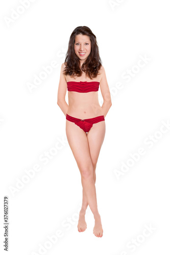 Full length portrait of an attractive cheerful woman wearing red bra and panties, studio photo isolated in front of white background