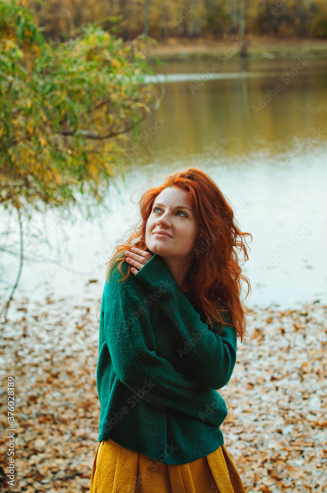 Portrait of a beautiful red-haired girl with freckles and blue eyes in autumn park Portrait of a beautiful red-haired girl with freckles and blue eyes in autumn park