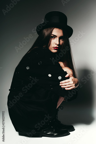 woman sitting in black dress and hat