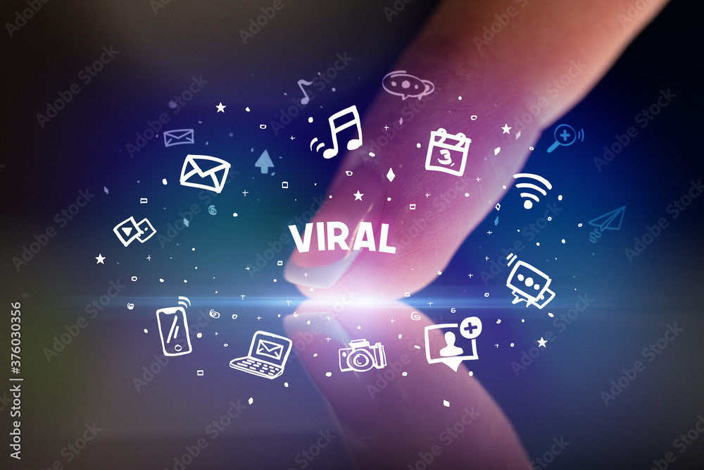Finger touching tablet with drawn social media icons and VIRAL inscription, social networking concept Finger touching tablet with drawn social media icons and VIRAL inscription, social networking concept