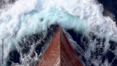 Red bow of a cargo ship breaking the waves. photo